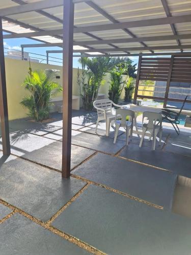 a patio with a table and chairs under a roof at Harmonious Villa in Flic-en-Flac with Private Pool in Flic-en-Flac