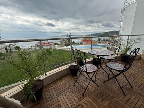 a balcony with a table and chairs and a view of the water at Luxury Apartments Calithea-Balchik, Free Parking in Balchik