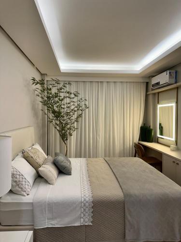 a bedroom with a large bed with a plant on it at Refúgio Sofisticado Beira Mar in Florianópolis