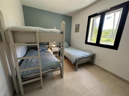 a bedroom with two bunk beds and a window at les resiniers in Moliets-et-Maa