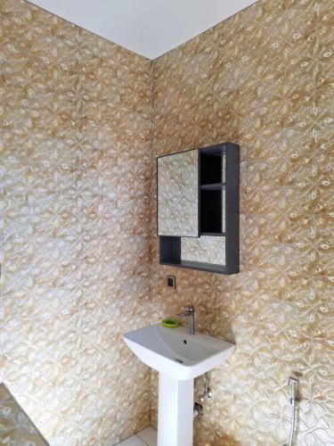 a bathroom with a sink and a mirror on a wall at Harmonious Villa in Flic-en-Flac with Private Pool in Flic-en-Flac