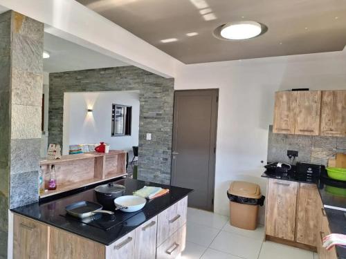 a kitchen with wooden cabinets and a black counter top at Harmonious Villa in Flic-en-Flac with Private Pool in Flic-en-Flac