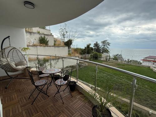 a balcony with a table and chairs and the ocean at Luxury Apartments Calithea-Balchik, Free Parking in Balchik