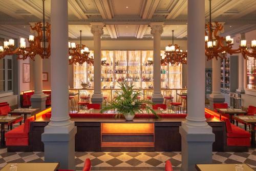 a restaurant with columns and tables and a bar at Helvetia&Bristol Firenze – Starhotels Collezione in Florence
