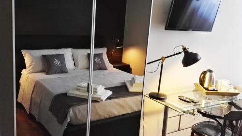 a bedroom with a bed and a desk with a lamp at Attico Barocco in Lecce