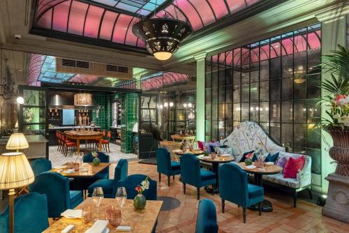 a restaurant with tables and chairs and a large window at Helvetia&Bristol Firenze – Starhotels Collezione in Florence