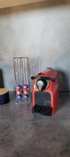 a toaster sitting on a table next to a vase at Appartement en centre ville in Bernay