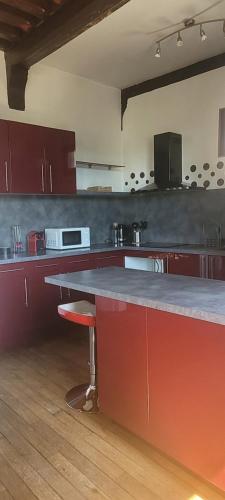 a kitchen with red cabinets and a counter top at Appartement en centre ville in Bernay