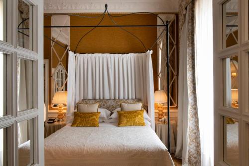 a bedroom with a large white bed with yellow pillows at Helvetia&Bristol Firenze – Starhotels Collezione in Florence