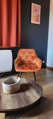 a brown leather chair in a room with a table at Appartement en centre ville in Bernay