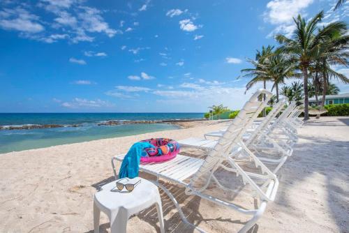 two lounge chairs on a beach with the ocean at On the Bay #103 Condo in Old Man Bay