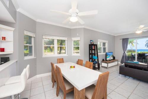 a dining room with a white table and chairs at On the Bay #103 Condo in Old Man Bay