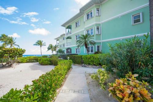 a building on the beach with the ocean in the background at On the Bay #103 Condo in Old Man Bay