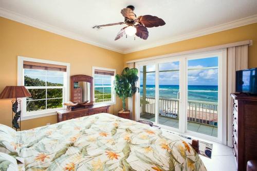 a bedroom with a bed and a view of the ocean at Parrot-ise 4 Bedroom Villa in Brinkleys
