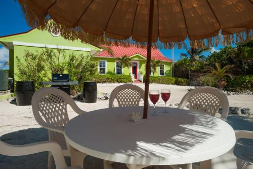 a white table with two glasses of wine on it at Parrot-ise 4 Bedroom Villa in Brinkleys