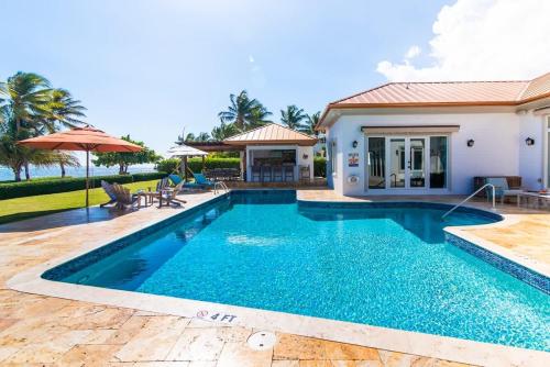 a swimming pool in front of a house at Faroway Luxury Villa in Half Way Pond
