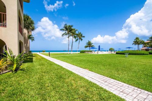 a walkway in front of a building with palm trees at Georgetown Villas #201 in George Town