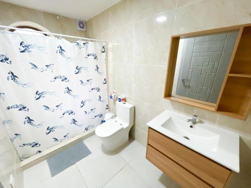 a bathroom with a toilet and a sink and a shower curtain at LOS CORALES Resort VILLAS & Apartments WIFI BEACH Club & SPA in Punta Cana