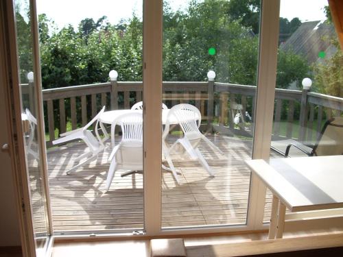 a porch with white chairs and a table on a deck at Männi Guesthouse in Haapsalu