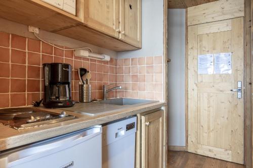 ヴァル・トランスにあるStudios & Appartements Ski aux Pieds - Val Thorensのシンクとカウンタートップのあるキッチン