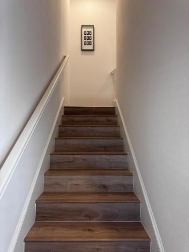 a staircase with wooden floors and white walls at Chic Beach Home Near Airport Casino Base in Gulfport