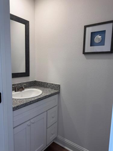 a bathroom with a sink and a mirror at Chic Beach Home Near Airport Casino Base in Gulfport
