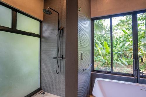 a bathroom with a bath tub and a window at Villa Asencia with pool and AC near Arrecife beach in Punta Uva