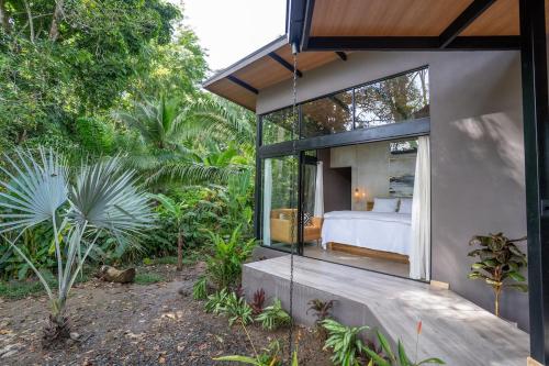 a bedroom in a house with a large glass window at Villa Asencia with pool and AC near Arrecife beach in Punta Uva