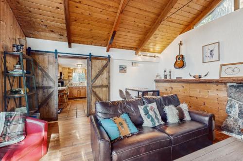 a living room with a leather couch and a fireplace at Secret Getaway in Lake Arrowhead