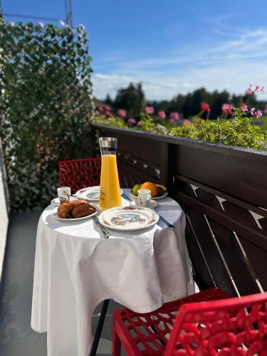 a table with food and a glass of orange juice at Hôtel l'Orée des Roches in Saales