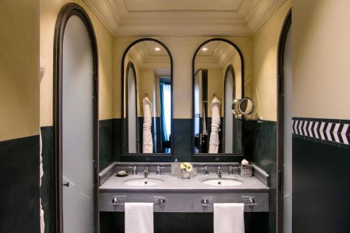 a bathroom with two sinks and three mirrors at Helvetia&Bristol Firenze – Starhotels Collezione in Florence
