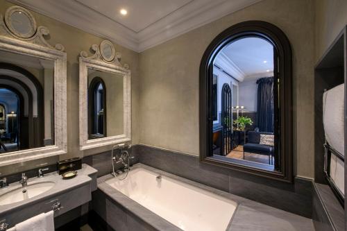 a bathroom with two sinks and two mirrors at Helvetia&Bristol Firenze – Starhotels Collezione in Florence