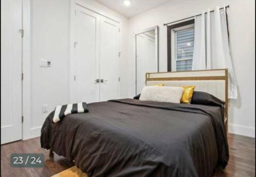 a bedroom with a large bed with a black blanket at Contemporary Luxury 3 Bdr Apt for 6 with Free Parking in Jersey City