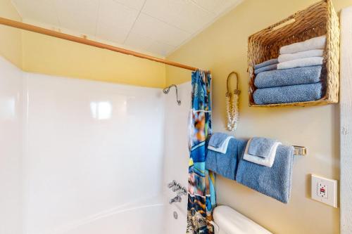 a bathroom with a shower and a toilet and towels at Lamplighter Inn Group Stay 2 in Bandon