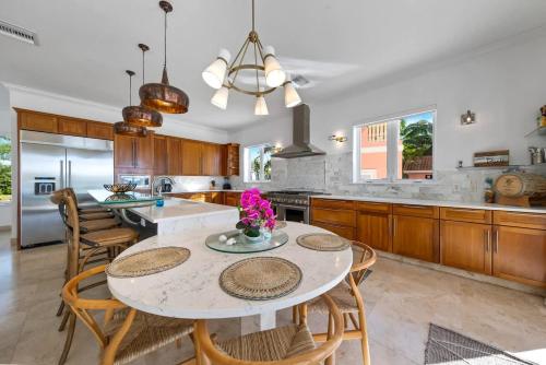 a kitchen with a table and some chairs and a counter at Pieces of Eight LUXE 6BR in Driftwood Village