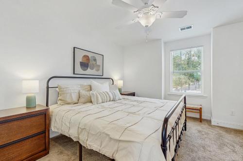 Un dormitorio blanco con una cama y un ventilador de techo. en Bowen Village 9201, en Charleston