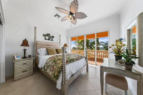 a bedroom with a bed and a desk and a window at Pieces of Eight LUXE 6BR in Driftwood Village