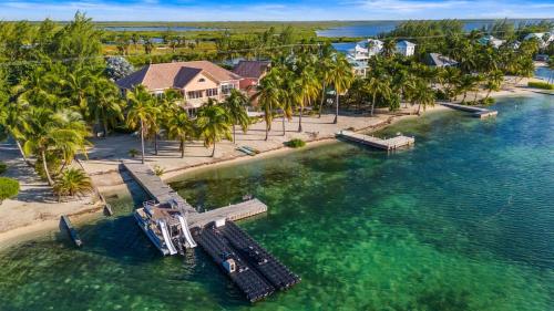 an aerial view of a house on a beach with palm trees at Pieces of Eight LUXE 6BR in Driftwood Village