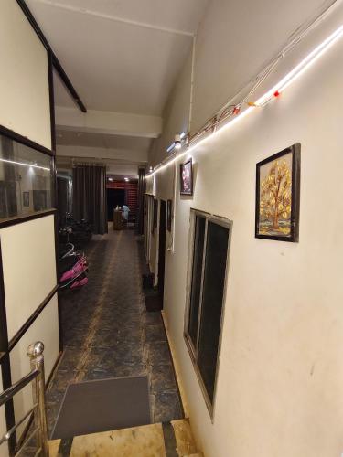 a long hallway with a room with paintings on the walls at AIIMS Nagar Homestay by Hezitt Stay in Bhubaneshwar