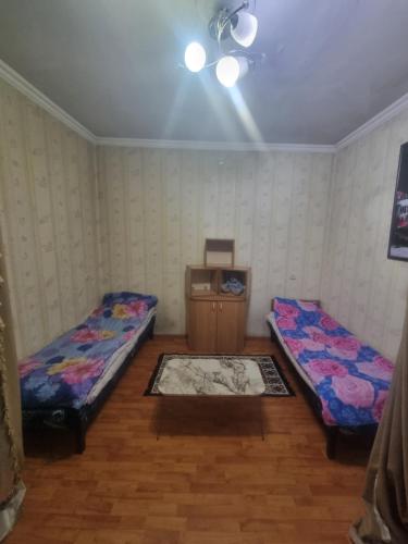 Una habitación con dos camas y una mesa dentro. en nizami m hostel, en Baku