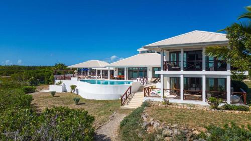 a house on the beach with a swimming pool at Songbird 4 BR Anguilla Villa in The Valley