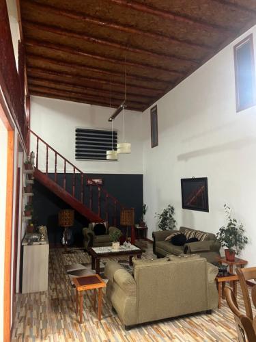 a living room with two couches and a staircase at El Relajo de Santa Cruz in Estación Colchagua