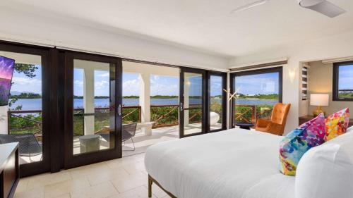 a bedroom with a bed and views of the ocean at Songbird 4 BR Anguilla Villa in The Valley