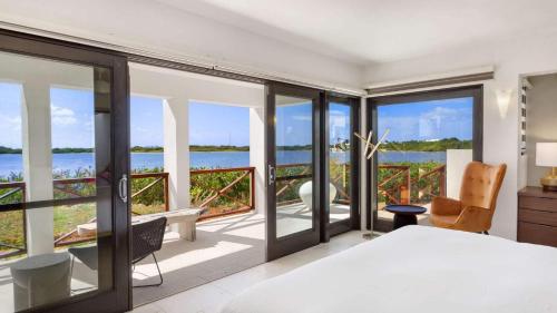 a bedroom with a view of the ocean at Songbird 4 BR Anguilla Villa in The Valley