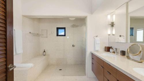a bathroom with a tub and a sink and a shower at Songbird 4 BR Anguilla Villa in The Valley