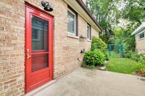 a red door on the side of a brick house at Pet-Friendly Abode, 2 Mi to Dtwn Evanston! in Evanston