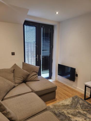 a living room with a couch and a flat screen tv at The Harbour Hideaway in Ramsgate