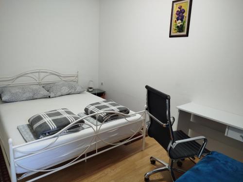 a bedroom with a bed and a desk and a chair at Apartman Ivana in Slavonski Brod