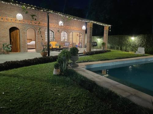 a house with a swimming pool in the yard at night at Colonial Style House in Villarrica