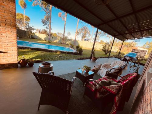 a patio with chairs and a pool in the background at Colonial Style House in Villarrica